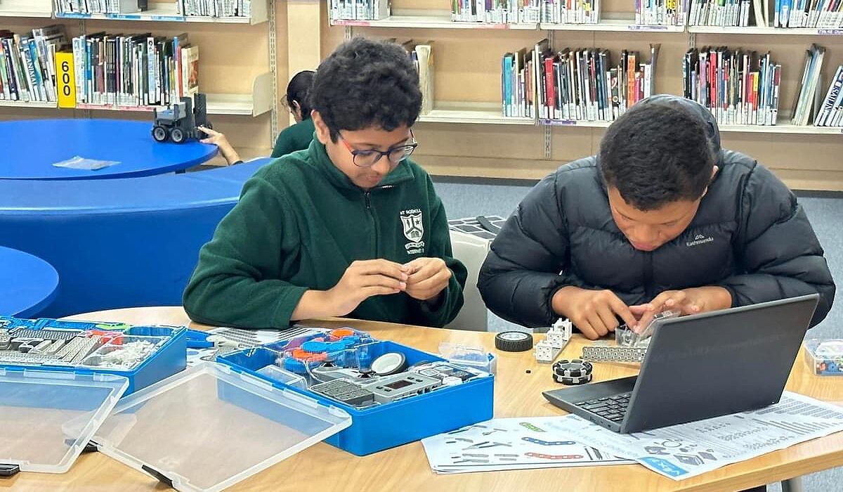 Two kids creating robots